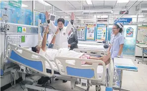  ?? APINYA WIPATAYOTI­N ?? A stroke patient raises his arms as directed by a physician during a therapy session at Khon Kaen Regional Hospital.