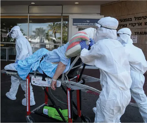  ?? (Flash90) ?? MAGEN DAVID ADOM workers, wearing protective clothing, bring a patient to the coronaviru­s unit at Sheba Medical Center in Ramat Gan this week.