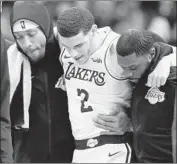  ?? Eric Christian Smith Associated Press ?? THE LAKERS’ Lonzo Ball is helped off the court after suffering an ankle injury in the third quarter. Ball finished with eight points and 11 assists.