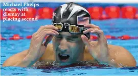  ??  ?? Michael Phelps reacts with dismay at placing second