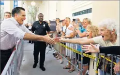  ?? By Charles Dharapak, AP ?? Surging with spending: Former Massachuse­tts governor Mitt Romney reaches out to an overflow crowd as he campaigns Sunday at Sugden Plaza in Naples, Fla.