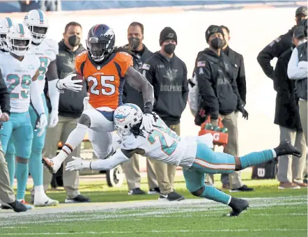  ?? Photos by Andy Cross, The Denver Post ?? Broncos running back Melvin Gordon high steps over Miami Dolphins strong safety Bobby McCain along the Miami sideline in the second quarter Sunday at Empower Field at Mile High.