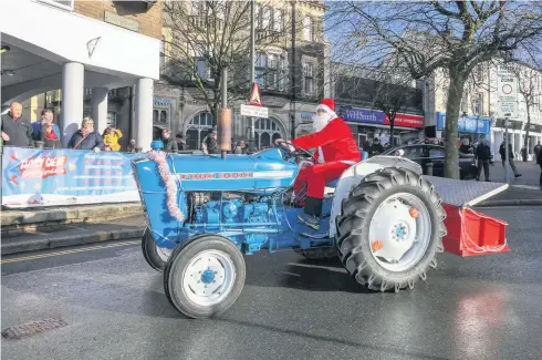  ??  ?? THE Carmarthen Christmas Charity Tractor Run saw some 17 tractors leave the start at Hagans Café at Pensarn before heading into the town centre to the joy of busy shoppers and children.The tractors then headed down to the Johnstown area and back down College Road, then via Debenhams to the A&amp;E department at Glangwili Hospital.They then moved on to Abergwili village and back along Priory Street and Jail Hill and back to Pensarn where some of the tractors made their way home whilst others headed up to Trevaughan for a bite to eat at the Plough and Harrow.Money raised from the run went to the Richmond Park School Observatio­n &amp; Assessment Unit (Dosbarth Dyfed).In our picture, Rhodri Reynolds leads the run into Lammas Street on his Ford 3000.Picture: Gary Jones