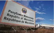  ?? Boris Grdanoski / Associated Press ?? A tank truck drives by a sign reading “Republic of Macedonia” entering from Greece. Signs will change gradually to say Republic of North Macedonia.