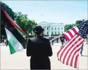  ?? NICHOLAS KAMM/AFP ?? Anti-Zionist Orthodox Jews of the Naturei Karta movement hold Palestinia­n and US flags to greet Palestinia­n President Mahmud Abbas at the White House in Washington, DC, on May 3.