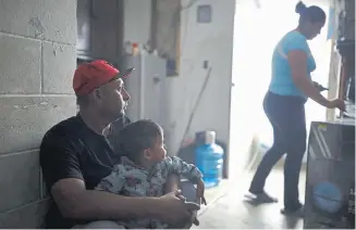  ??  ?? Juan Carlos Perla sits with his son, Joshua Perla, as his wife, Ruth Aracely Monroy, right, stands in their home on the outskirts of Tijuana, Mexico, on Jan. 28. The family was among thousands of U.S. asylum seekers returned to Mexico to wait while their claim makes its way through the U.S. courts.