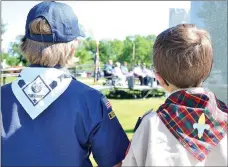  ?? TIMES photograph by Annette Beard ?? Young Boys Scouts waited patiently until it was their turn to raise the Arkansas and POW flags at the memorial dedication in May. Speakers from the Veterans of Foreign Wars, USS Snook Base, Congressma­n John Boozman’s office and Mayor Jackie Crabtree were seated on the platform to speak. The Veterans of Foreign Wars Post 8109 built a veterans memorial in Pea Ridge with monuments naming veterans from different wars.