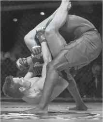  ??  ?? Fred Stonehouse, left, tries to catch Devonte Smith in an arm bar during their Gladiators of the Cage 21 bout in Pittsburgh on June 4.