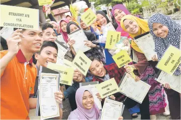  ??  ?? SMK Long Ghafar students show their PT3 result slips. — Bernama photo