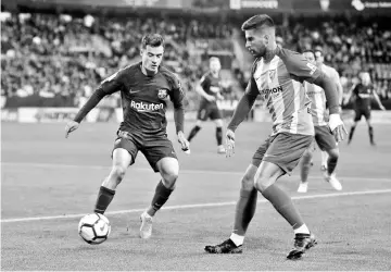  ?? - AFP photo ?? Barcelona’s Brazilian midfielder Philippe Coutinho (L) vies with Malaga’s Spanish forward Samu Garcia during the Spanish league football match between Malaga CF and FC Barcelona at the La Rosaleda stadium in Malaga on March 10, 2018.