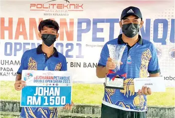  ??  ?? Fadzrul (left) and Aznil pose with their prizes after winning the Sabah Open Petanque Doubles Tournament at PKK Petanque Arena over the weekend.