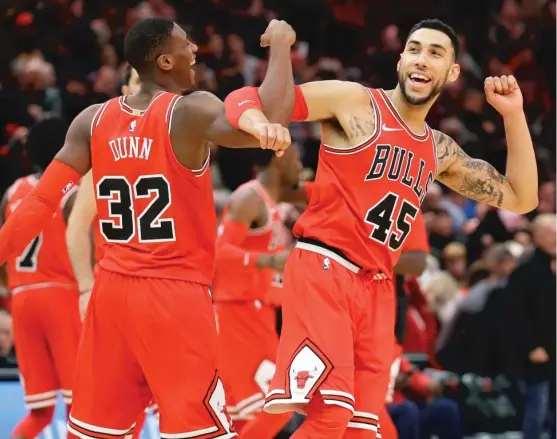  ??  ?? Kris Dunn and Denzel Valentine, who had 13 points apiece, celebrate after the Bulls’ 103- 100 victory against the Utah Jazz on Wednesday at the United Center. | NAM Y. HUH/ AP