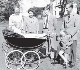  ??  ?? Dec. 19, 1965: The Queen and Prince Philip, with members of her family on the grounds of Windsor Castle, in Windsor, England. From left, Princess Anne, Prince Charles, Prince Andrew. In the pram is Prince Edward.