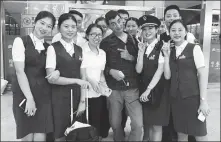  ?? PROVIDED TO CHINA DAILY ?? British comedian Nigel Dixon poses for a photo with high-speed train attendants upon his arrival in Wuhan on a previous trip in September 2018.