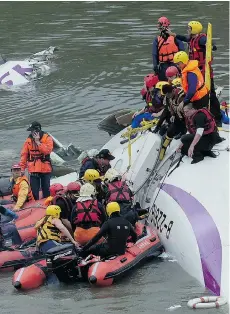  ?? SAM YEH/AFP/GETTY IMAGES ?? Rescue personnel work to free passengers from a TransAsia plane that crashed into a river in Taipei, Taiwan, on Wednesday.