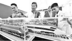  ?? — Bernama photo ?? Members of the public are seen looking at train models. Various estimates have claimed that the China-backed ECRL could be done for less than RM40 billion but that its cost had been inflated to RM60 to RM70 billion.