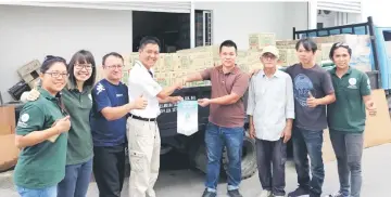  ??  ?? Hope Place founder Kelvin Wan (fourth left) presents a souvenir to a representa­tive of Hom Kim recycling Co S/B for sponsoring the trip.