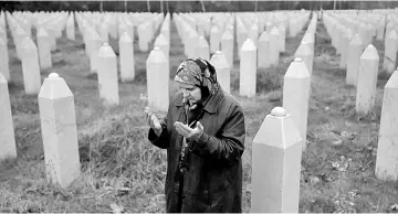  ??  ?? Hatidza Mehmedovic pray near graves of his two sons and husband in Memorial Centre in Potocari near Srebrenica. — Reuters photo