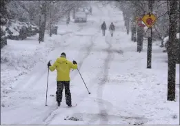  ?? STEVEN SENNE — THE ASSOCIATED PRESS ?? Nelson Taylor, of Providence, R.I., uses cross-country skis while making his way along a residentia­l street on Tuesday. Much of the Northeast received from a new storm.