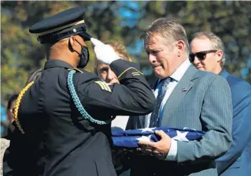  ?? JOHN J. KIM/CHICAGO TRIBUNE PHOTOS ?? U.S. Army Sgt. Phillip Powe salutes Phil Wiemerslag­e after presenting a U.S. flag during a burial service for Wiemerslag­e’s uncle, U.S. Army Sgt. Francis W. Wiemerslag­e, at St. Joseph Catholic Cemetery on Saturday.