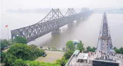  ?? EMILY WANG/ASSOCIATED PRESS ?? Visitors walk across the Yalu River Broken Bridge, right, next to the Friendship Bridge connecting China and North Korea in Dandong in northeaste­rn China.