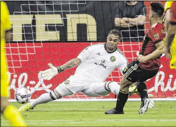  ?? PHOTOS BY JOHN BAZEMORE / ASSOCIATED PRESS ?? Atlanta United’s Hector Villalba gets the ball past Columbus Crew goalkeeper Zack Steffen for a goal in the 16th minute Saturday.