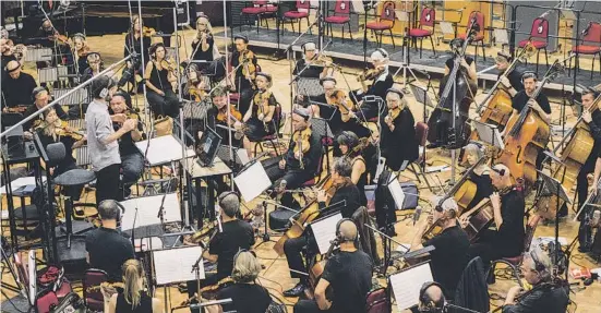  ??  ?? Lucas Vidal con los músicos de Abbey Road en pleno proceso de grabación de la banda sonora de LaLiga.