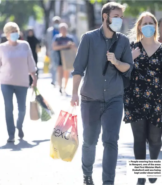  ?? Matthew Horwood ?? People wearing face masks in Newport, one of the areas that First Minister Mark Drakeford said was being kept under observatio­n