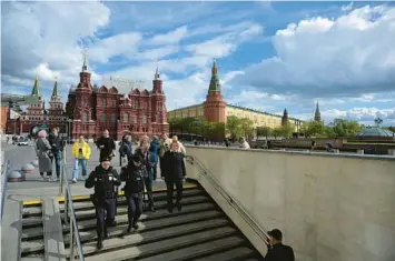  ?? NATALIA KOLESNIKOV­A/GETTY-AFP ?? The Central Bank of Russia has predicted inflation will run 18 to 23 percent this year in wake of sanctions from the West. Above, police officers enter an undergroun­d passage this week at Manezhnaya Square in Moscow.