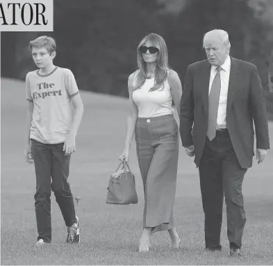  ?? CHRIS KLEPONIS/POOL/GETTY IMAGES ?? U.S. President Donald Trump, first lady Melania Trump and their son Barron arrive at the White House on Sunday. Later that evening Melania tweeted that she and her son had moved into the White House from Trump Tower.