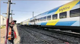  ?? RICHARD GRAULICH / THE PALM BEACH POST ?? The Brightline passenger train makes its way for the first time on the FEC tracks south of the West Palm Beach station Thursday.