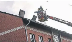  ?? ?? Ein Feuerwehrm­ann im Korb einer Drehleiter, die die Retter vor dem Haus positionie­rt hatten, um den Dachbrand zu löschen.