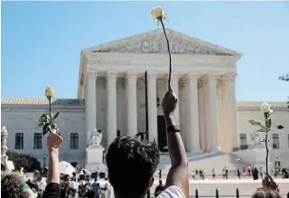  ?? CHIP SOMODEVILL­A
GETTY IMAGES ?? Members of CASA, an advocacy organizati­on for Latino and immigrant people, hold up white roses in honour of Justice Ruth Bader Ginsburg at the U.S. Supreme Court Wednesday.