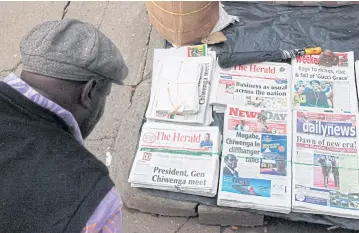  ?? REUTERS ?? A man reads the headlines of newspapers for sale in Harare yesterday. The future of Zimbabwe’s leadership remains unclear.