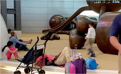  ?? AFP file ?? Passengers of cancelled flights wait at Hamad Internatio­nal Airport in Doha, Qatar. —