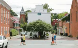  ?? PATRICK SEMANSKY/AP 2014 ?? Strollers cross a street in Shepherdst­own, W.VA., in the state’s Eastern Panhandle. Just over an hour from Washington, the region is the state’s fastest growing.