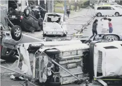  ??  ?? 0 Damaged cars strewn about a street in Osaka after the storm