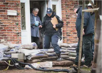  ??  ?? Des pompiers quittent la maison d’un résidant de la rue Paquin, à L’Île-Bizard.