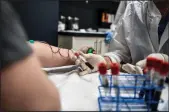  ?? CHANDAN KHANNA/AFP VIA GETTY IMAGES ?? Laymis Alvarez, right, takes blood samples from Heather Lieberman, 28, as she participat­es in a COVID19 vaccine study at the Research Centers of America in Hollywood, Fla., on Aug. 13.