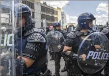  ?? ALYSSA POINTER / ALYSSA.POINTER@AJC.COM ?? Police officers clad in tactical gear form a line Sunday to block protesters from walking down Centennial Olympic Drive NW toward the CNN Center during the third day of demonstrat­ions in Atlanta.