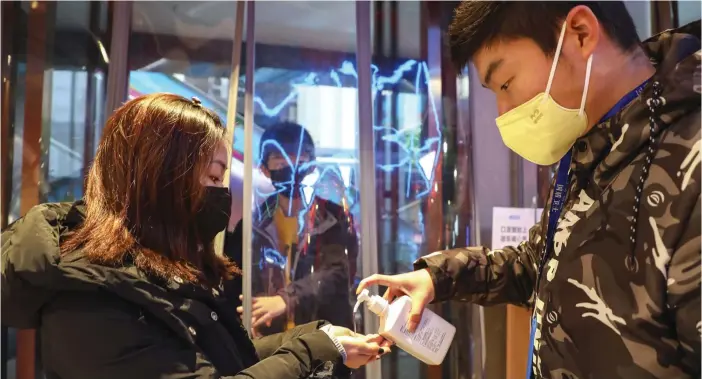  ?? Foto: Chinatopix/ap/tt ?? Personalen på ett köpcenter i Wuhan delar ut handsprit till kunder.