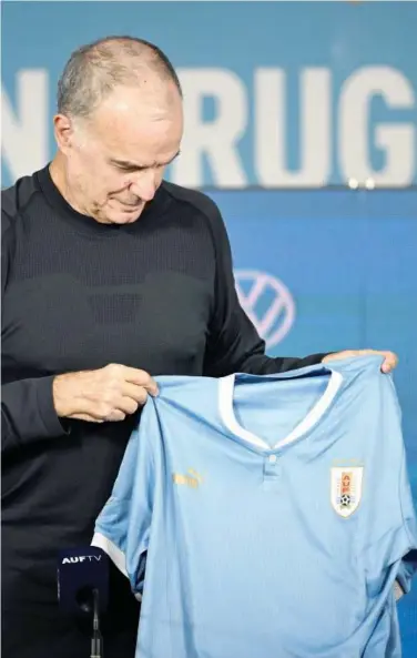  ?? Agence France-presse ?? Argentine Marcelo Bielsa holds a jersey of the Uruguayan national football team during his presentati­on as coach of the team.