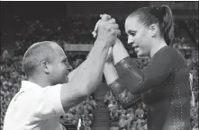  ?? AP ?? Chellsie Memmel is congratula­ted by her coach and father, Andrew Memmel, after completing her routine on the floor exercise at the world championsh­ips in Melbourne, Australia in 2005.