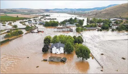  ?? VAGGELIS KOUSIORAS AP ?? Floodwater­s cover houses and farms in Kastro, Greece, on Sept. 7. The storm caused extensive damage in Greece, Bulgaria and Turkey, a region where such storms are up to 10 times more likely and up to 40 percent more intense because of climate change, scientists said.
