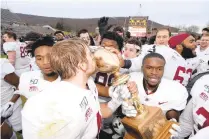  ?? RICK KINTZEL/THE MORNING CALL ?? Lafayette players kiss and surround the trophy Nov. 23, 2019, after the 155th game against Lehigh at Goodman Stadium in Bethlehem. Lafayette won, 17-16.