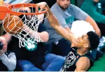  ?? Michael Dwyer/Associated Press ?? ■ Milwaukee Bucks' Giannis Antetokoun­mpo dunks during overtime in Game 1 of an NBA first-round playoff series against the Boston Celtics on Sunday in Boston. The Celtics won 113-107.