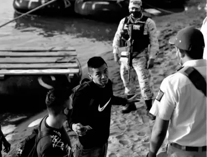  ?? AP PHOTO/EDUARDO VERDUGO ?? Mexican immigratio­n agents stop people who crossed the Suchiate River, the natural border between Guatemala and Mexico, to see their identifica­tion documents as they enforce limits on all but essential travel near Ciudad Hidalgo, Mexico, on Monday.