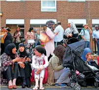  ?? AFP ?? People affected by the fire sit on the pavement outside a temporary aid centre in west London on Wednesday. —