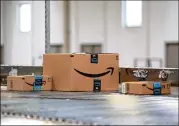  ?? BESS ADLER / BLOOMBERG ?? Packages move along a conveyor belt at an Amazon facility in Robbinsvil­le, N.J. Records show thousands of Amazon employees rely on government aid.
