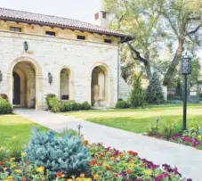  ??  ?? The exterior’s gold and buff limestone with a red tile roof sets the textural and color palettes for landscapin­g details.